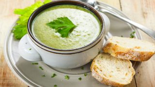 Homemade cream of celery soup garnished with celery leaves