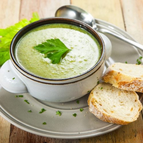 Homemade cream of celery soup garnished with celery leaves