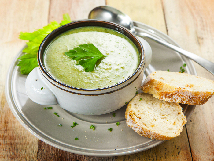 Homemade cream of celery soup garnished with celery leaves