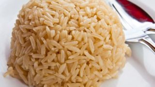 A closeup view of cooked brown rice with a spoon
