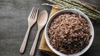Brown/Coarse Rice with wooden spoon and fork, rice seed
