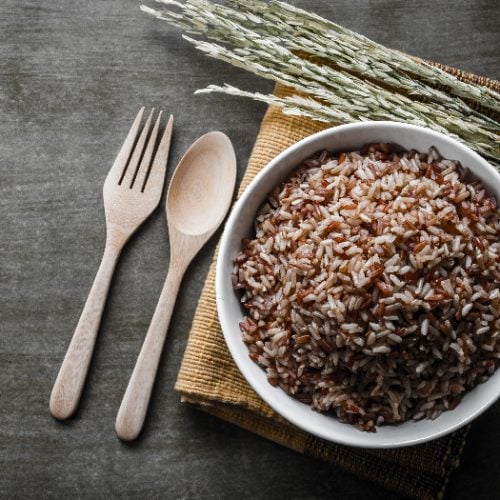 Brown/Coarse Rice with wooden spoon and fork, rice seed