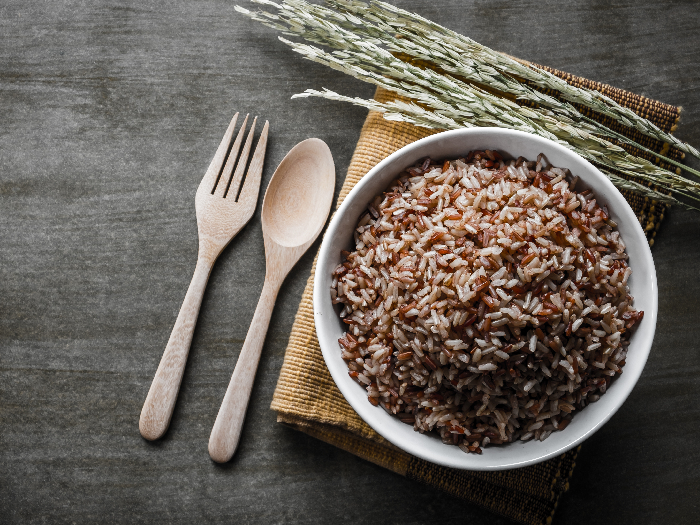 Brown/Coarse Rice with wooden spoon and fork, rice seed