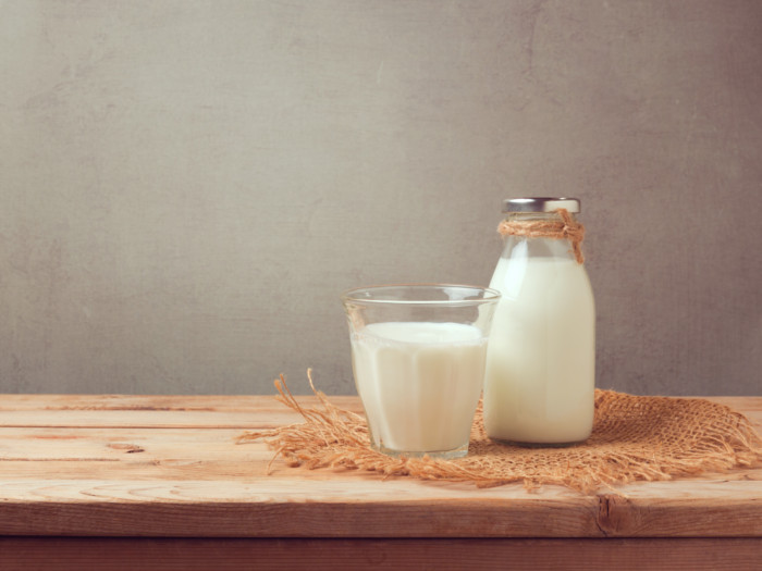 Een glas en een pot buffelmelk op een jute doek