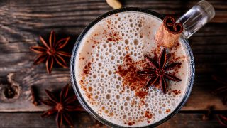 Homemade bulletproof tea with anise and cinnamon stick in a glass mug