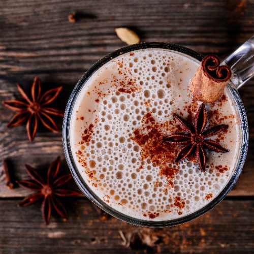 Homemade bulletproof tea with anise and cinnamon stick in a glass mug