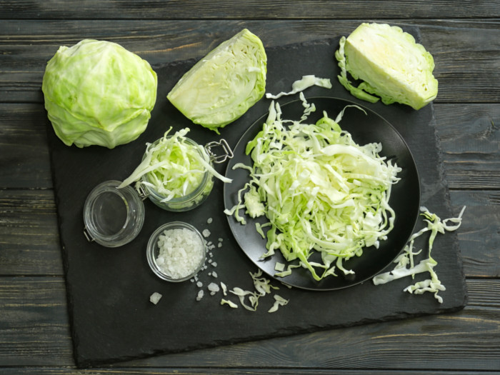 Whole cabbage with chopped cabbage on a wooden table