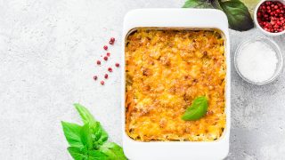 Cheesy stuffed pineapple casserole on concrete background