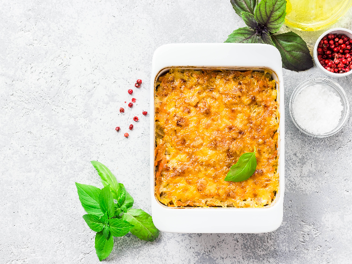 Cheesy stuffed pineapple casserole on concrete background