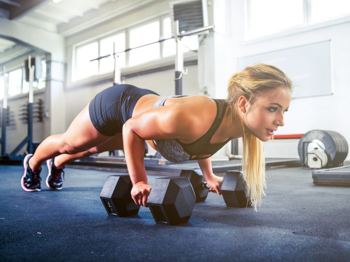 A woman performing calisthenics at the gym