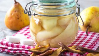 A close-up shot of canned pears in a glass jar