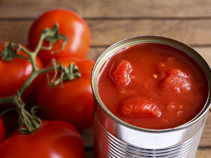 Blended fresh tomatoes kept beside fresh tomatoes