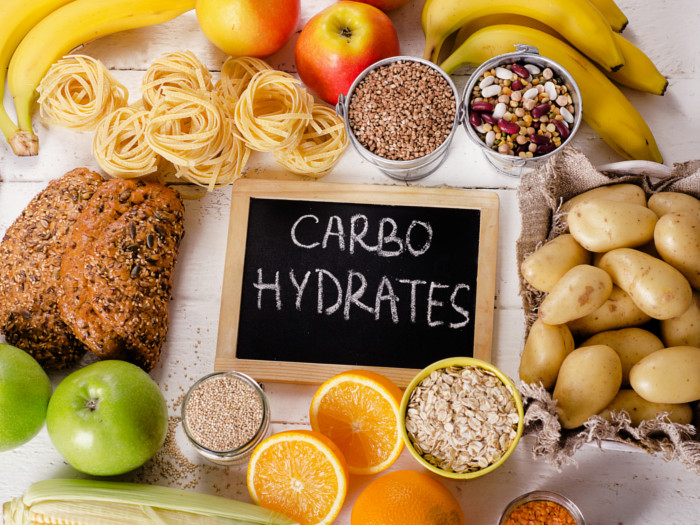 A signboard reading carbohydrates surrounded by food on all sides