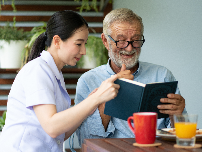 Young nurse taking care of a senior man at home