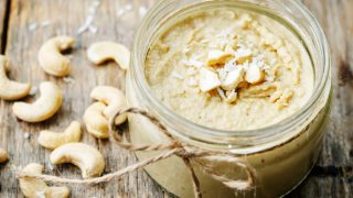 Cashew butter in a jar with whole cashews and coconut