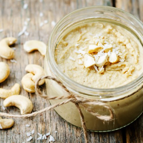 Cashew butter in a jar with whole cashews and coconut