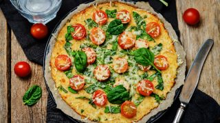 Cauliflower pizza crust with tomato and spinach