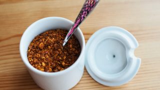Small jar of cayenne pepper with a spoon in it.