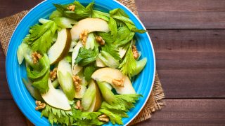 Fresh celery, pear, and walnut salad on blue plate