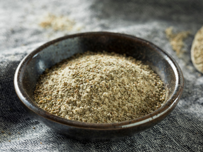 Celery salt in a flat black ingredient dish on a grey placemat