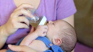 A woman feeding her baby with bottle