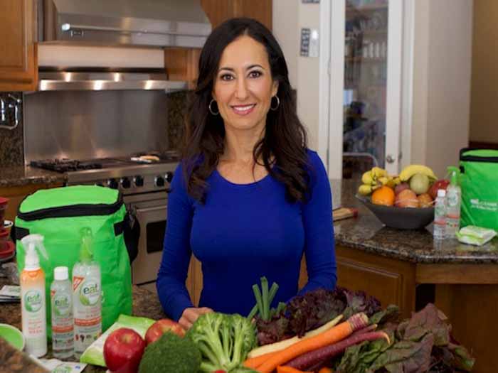 Chef Mareya Ibrahim, standing in her kitchen, looking into the camera and smiling