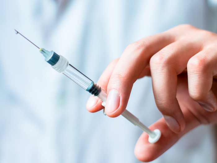 A doctor holding a syringe