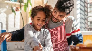Father and daughter baking in the kitchen and having fun