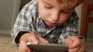 A close-up shot of a child playing with the mobile phone