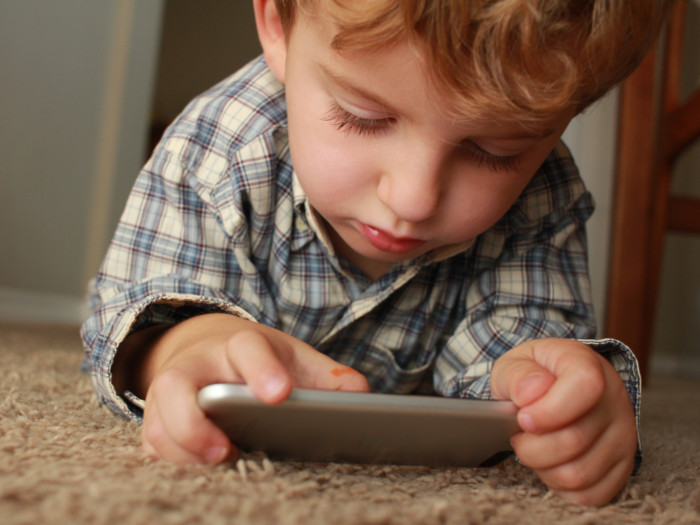 A close-up shot of a child playing with the mobile phone