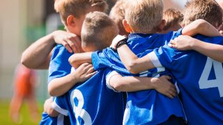 Boys in sports uniforms hugging each other before game