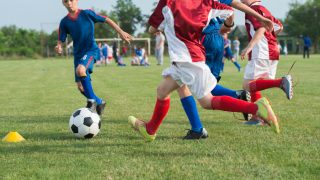 Boys playing football on a sports field