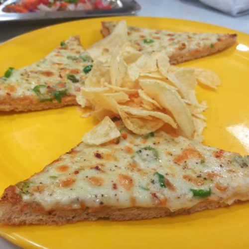 Triangles of cheese chilli toast on a yellow plate with wafers