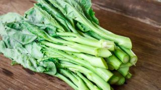 Fresh Chinese broccoli on a wooden counter