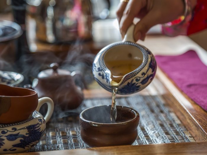 A woman pouring tea into a cup