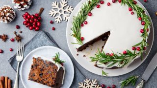 Christmas fruit cake and a slice on a white plate