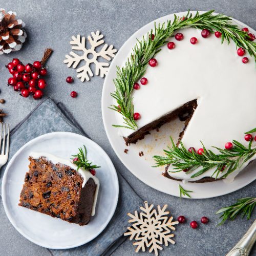 Christmas fruit cake and a slice on a white plate