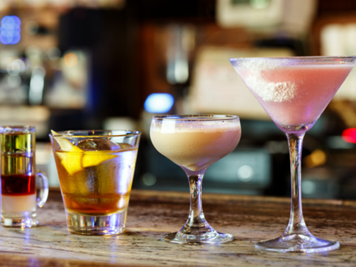 Cocktail drinks in different glasses on a wooden counter