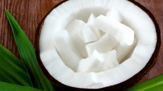 A close-up shot of coconut pieces within a coconut sliced into half