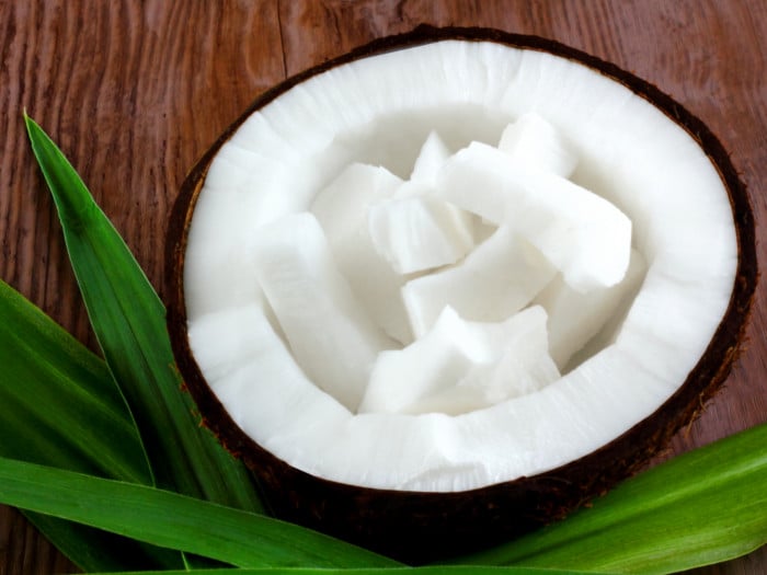 A close-up shot of coconut pieces within a coconut sliced into half
