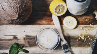 Coconut cream, sliced lemon, lemon rind, and whole coconut on wood