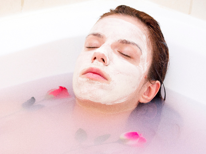 A girl with a face mask on in the shower