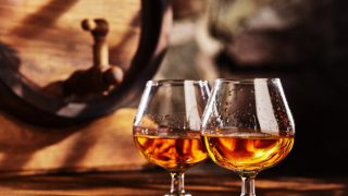 Cognac served in two glasses on a counter in a distillery
