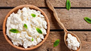 Close up of cottage cheese in a bowl on a wooden table