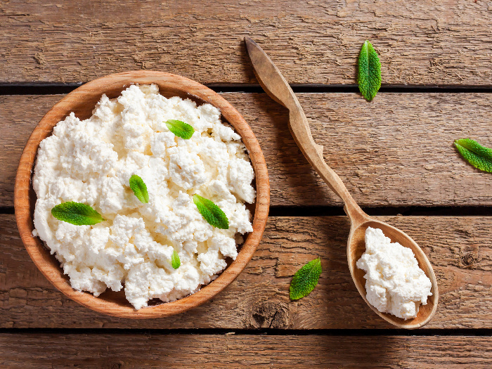 Close up of cottage cheese in a bowl on a wooden table