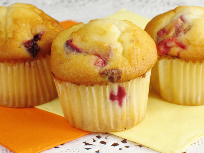 Three muffins placed on yellow napkins.