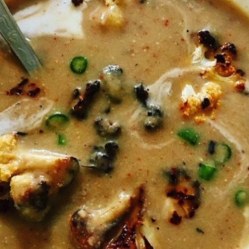 Delicious creamy cauliflower soup with crispy cauliflower croutons in a white bowl