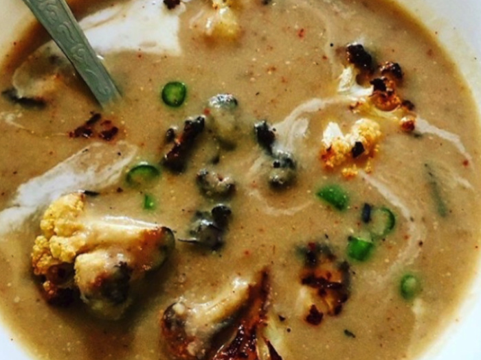 Delicious creamy cauliflower soup with crispy cauliflower croutons in a white bowl