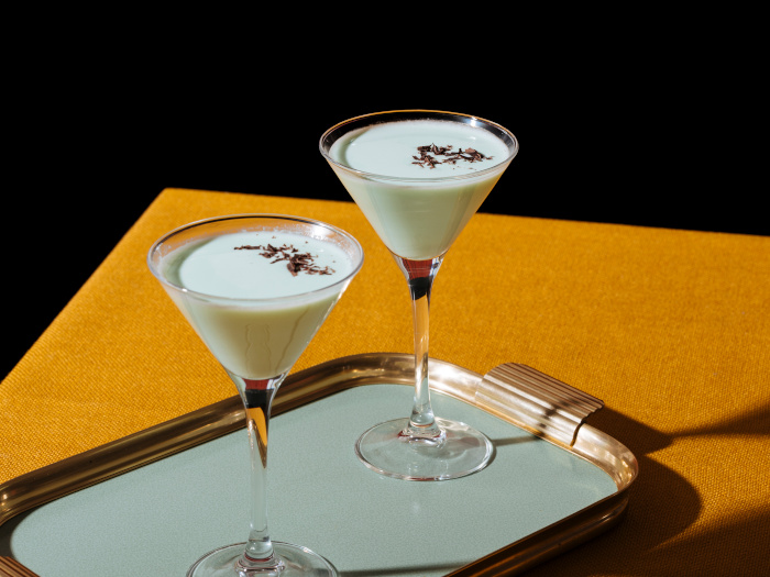 Two cocktail glasses of grasshopper made with créme de menthe