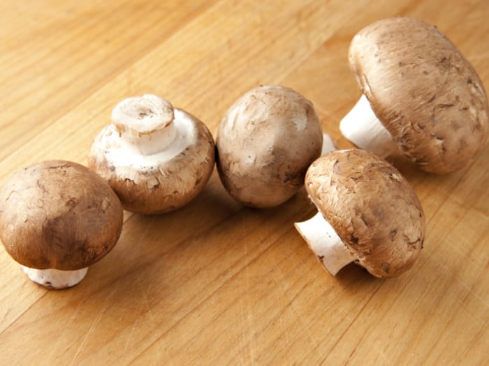 Cremini mushrooms on a wooden counter